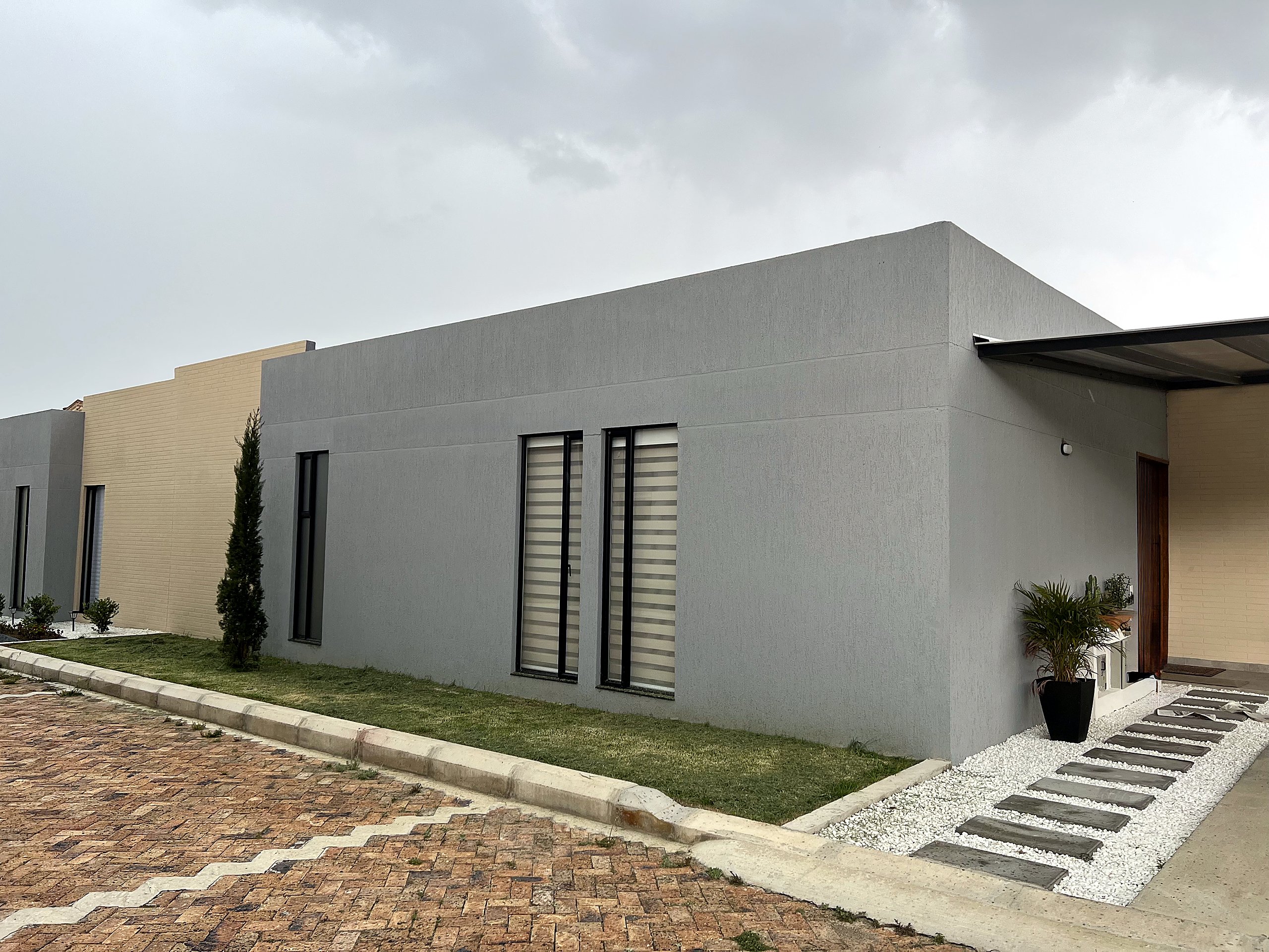 Fachada de vivienda contemporánea sobre ladera, proyecto de Urbe.Co